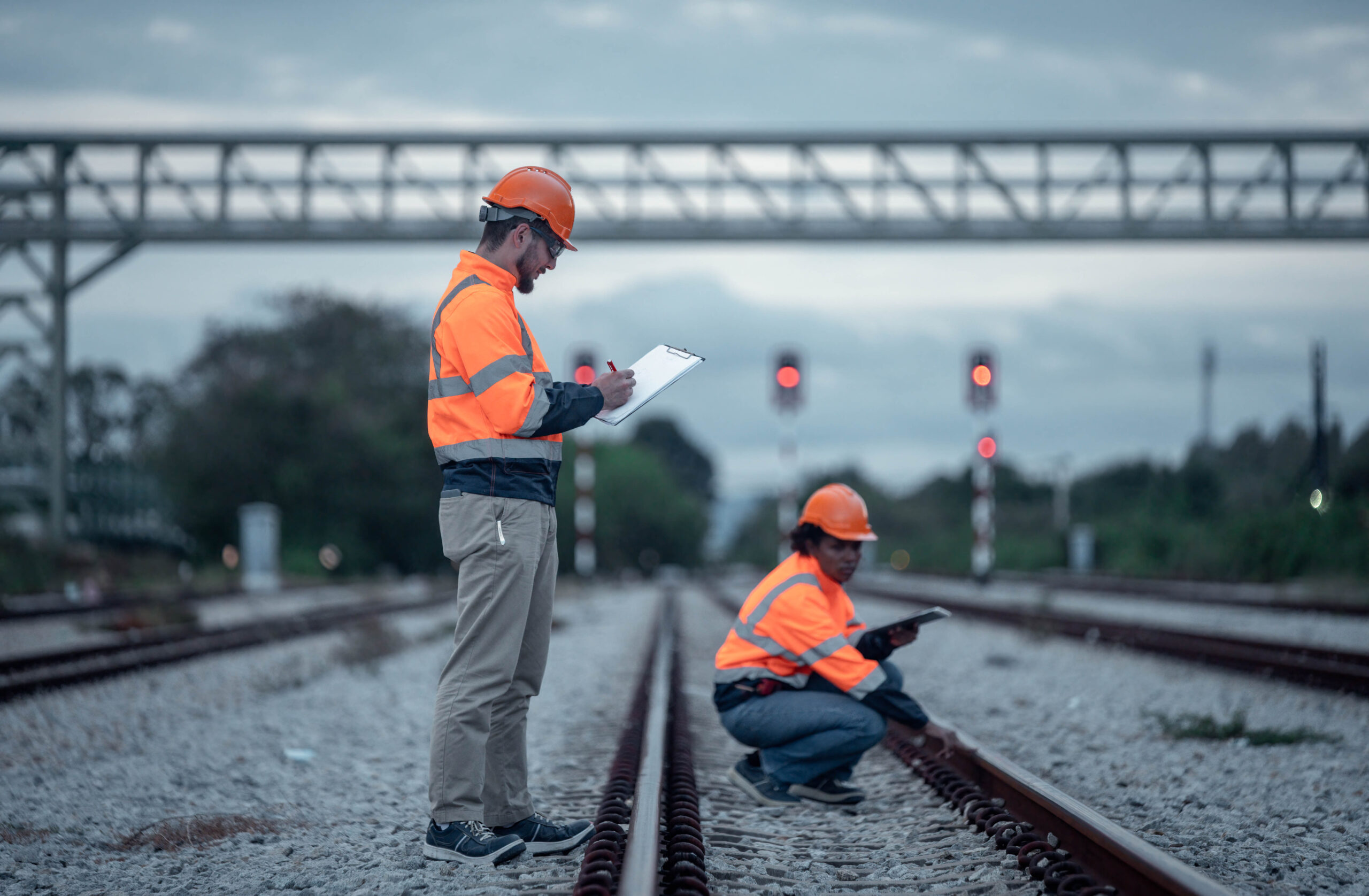 Engineer under discussion inspection and checking construction process railway switch and checking work on railroad station .Engineer wearing safety uniform and safety helmet in work. Engineer under discussion inspection and checking construction process railway switch and checking work on railroad station .Engineer wearing safety uniform and safety helmet in work.